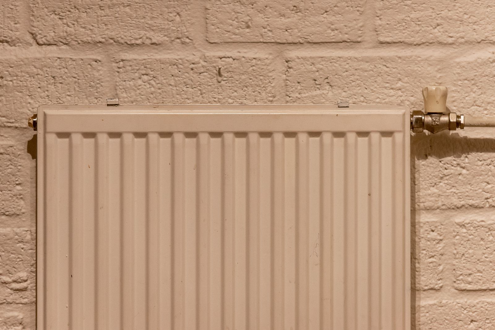 Radiator hung and piped in on a brick wall
